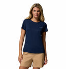 A woman with long blonde hair wears the Columbia Womens Zero Rules Light Technical T-shirt in navy and light tan shorts, ideal for hiking, standing against a plain white background.