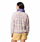 A woman with brown hair, seen from behind, wears a Columbia Womens Sequoia Grove™ Printed Half Zip Fleece with pastel geometric prints, purple collar, and tan shorts.