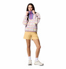 A woman in a Columbia Womens Sequoia Grove™ Printed Half Zip Fleece stands against a white background, pairing the recycled polyester fleece with yellow shorts, white socks, and sneakers as she holds the collar and looks ahead.