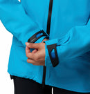 A person wearing the Columbia Womens Saudan Pro™ 3L Shell Jacket in bright blue adjusts the Velcro strap on the sleeve, highlighting the cuff’s details engineered for extreme weather protection.