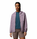 A woman stands facing forward in a Columbia Womens Khyex Pro™ Wind Jacket—an ultralight, wind-resistant jacket with UPF 50 sun protection—over a teal shirt and brown shorts, her hands by her sides against a plain white background.