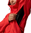 A woman in a Columbia Womens Trailborne 2.5L Waterproof Shell Jacket unzips a large underarm vent, revealing the inner lining; only her lower face is visible against a white background.
