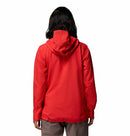 A person with shoulder-length dark hair is seen from behind wearing a bright red Columbia Womens Trailborne 2.5L Waterproof Shell Jacket and light brown pants against a plain white background.