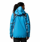 A person with curly hair in a ponytail wears a Columbia Womens Whistler Peak Waterproof Shell Jacket, bright blue with gray accents, shown from the back against a plain white background.