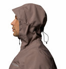 A man in profile wears Columbias Mens Trailborne 2.5L Waterproof Shell Jacket with a brown hood and adjustable drawstring, featuring Omni-Tech technology, against a white background.