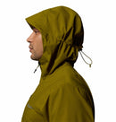 A person in profile, facing left, wears a Columbia Mens Trailborne 2.5L Waterproof Shell Jacket in olive green with the hood up and drawstrings cinched, set against a plain white background.