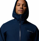A man wears the Columbia Mens Trailborne 2.5L Waterproof Shell Jacket in navy blue, zipped to the neck, confidently facing the camera against a white background.