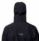 A close-up of a person from the back wearing Columbias Mens Saudan Pro 3L Waterproof Shell Jacket in black, featuring a hood and the Columbia logo on the upper back.