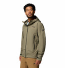 A man in a khaki Columbia Mens Saudan Pro 3L Waterproof Shell Jacket and tan pants stands facing slightly left, head turned right, against a plain white background.
