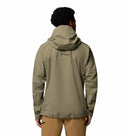 A man with short curly hair, seen from behind, wears a light olive Columbia Mens Saudan Pro 3L Waterproof Shell Jacket and tan pants against a plain white background.