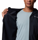 A person in a light blue shirt and a partially unzipped, open Columbia Mens Khyex Pro™ Wind Jacket stands against a white background, showing only the lower half of their face.