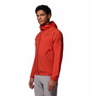 A man wearing the Columbia Mens Khyex Pro™ Wind Jacket in bright red with UPF 50 protection and light gray pants stands slightly sideways against a plain white background.