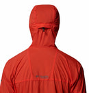 A person is shown from the back wearing a bright red Columbia Mens Khyex Pro™ Wind Jacket with the hood up. The Columbia logo near the shoulders highlights its water- and stain-resistant features for any adventure.