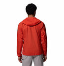 A person with short curly hair is seen from the back against a plain white background wearing the Columbia Mens Khyex Pro™ Wind Jacket in bright orange with UPF 50 protection and light gray pants.