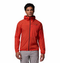 A person wearing the Columbia Mens Khyex Pro™ Wind Jacket in bright red with water and stain resistance, a front zipper, and gray pants stands facing forward against a plain white background.