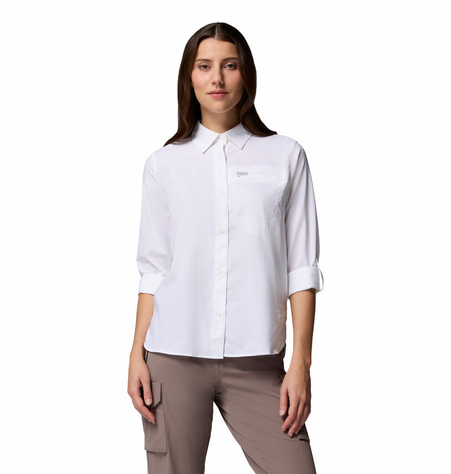 A woman faces forward, wearing the Columbia Womens Silver Ridge Utility II Long-Sleeve Shirt (white, sleeves rolled to elbows) with UPF 50 sun protection and light brown cargo pants. The background is plain white.