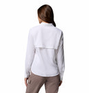 A woman with long brown hair faces away, wearing the Columbia Womens Silver Ridge Utility II Long-Sleeve Shirt in white and light brown moisture-wicking pants with side pockets, against a plain white background. The shirt provides UPF 50 sun protection and flap detail.
