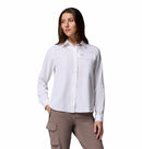 A woman poses against a white background wearing the Columbia Womens Silver Ridge Utility II Long-Sleeve Shirt and taupe cargo pants, looking slightly to the side with one hand in her pocket.