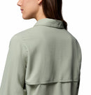 A woman with long brown hair, seen from behind and in profile, wears the Columbia Womens Silver Ridge Utility II Long-Sleeve Shirt in light sage green with UPF 50 protection. The background is plain white.