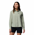 A woman models the Columbia Womens Silver Ridge Utility II Long-Sleeve Shirt in light green, featuring moisture-wicking fabric and UPF 50 sun protection, paired with black shorts. She stands against a white background, looking slightly to the side.