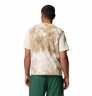 Person wearing a tie-dye t-shirt and green shorts on a white background