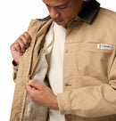 Person wearing a beige jacket with Columbia logo, focusing on the zipper.