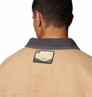 Person wearing a beige jacket with a retro style vintage Columbia logo on the back
