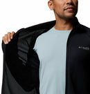 A man, with only the lower half of his face visible, holds open a Columbia Mens Summit Step™ Full Zip Technical Fleece, showing its inner lining over a light blue t-shirt.
