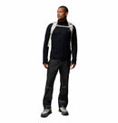 A man in a neutral pose wears a Columbia Mens Summit Step™ Full Zip Technical Fleece in black, paired with black pants, gray hiking shoes, and a beige lightweight backpack, looking to the side against a plain white backdrop.