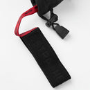 A close-up of a black fabric strap with embossed text and a red loop—features reminiscent of the durable fastenings on the Hestra Army Leather Heli Ski Glove—attached to a black cord lock on a white background.