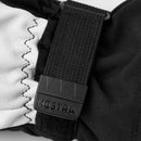 A close-up of the Hestra Army Leather Heli Ski Glove in black and white showcases a black strap with a plastic buckle labeled “HESTRA,” highlighting its detailed stitching and textured fabric.