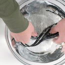 Person washing black straps in a glass bowl with water