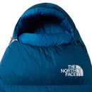 A close-up of a blue The North Face Blue Kazoo Down Sleeping Bag (-7°C) with a hood, displaying the brand’s white logo on the front.
