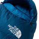 A close-up of a blue The North Face Blue Kazoo Down Sleeping Bag (-7°C), featuring the brand’s white logo and a partially unzipped section that reveals the inner lining.