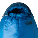 A blue Cat’s Meow Sleeping Bag (-7°C) from The North Face, featuring a hood with a cinched opening and recycled synthetic insulation, displays the prominent brand logo on the front.