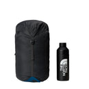 A black backpack stands upright next to a matching black water bottle, both featuring The North Face logo in white. Ideal for your next adventure, these items pair perfectly with outdoor essentials like the Cat’s Meow Sleeping Bag (-7°C) from The North Face and other gear made with recycled synthetic insulation. Both products are displayed on a plain white background.