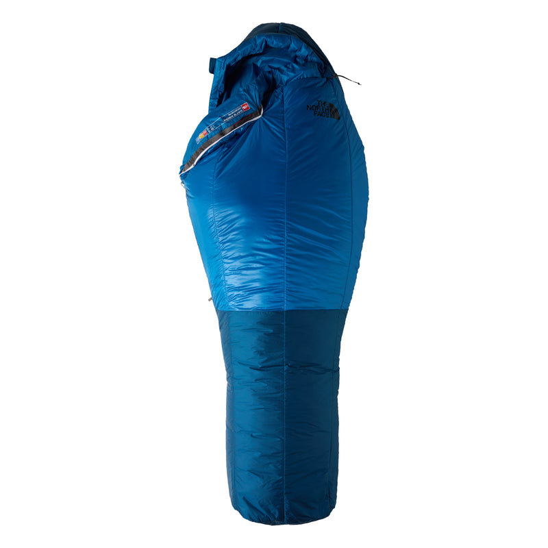 A blue Cat’s Meow Sleeping Bag (-7°C) by The North Face, featuring a shiny insulated shell with recycled synthetic insulation, a hood, and a zippered side—specifically designed for cold weather camping—with The North Face logo displayed on the upper section.