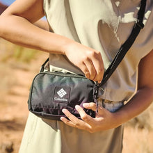 Person holding a Columbia cross body bag outdoors