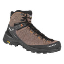 The Salewa Men’s Alp Trainer 2 Mid GORE-TEX Hiking Boot is a brown and black waterproof boot with orange accents, equipped with a rugged sole and ankle support, designed for challenging mountain terrain.