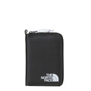 The North Face Base Camp Voyager Wallet is a sleek black zippered travel wallet made from recycled fabric, featuring the brands white logo at the bottom right corner and a convenient pocket for a tracking tag.