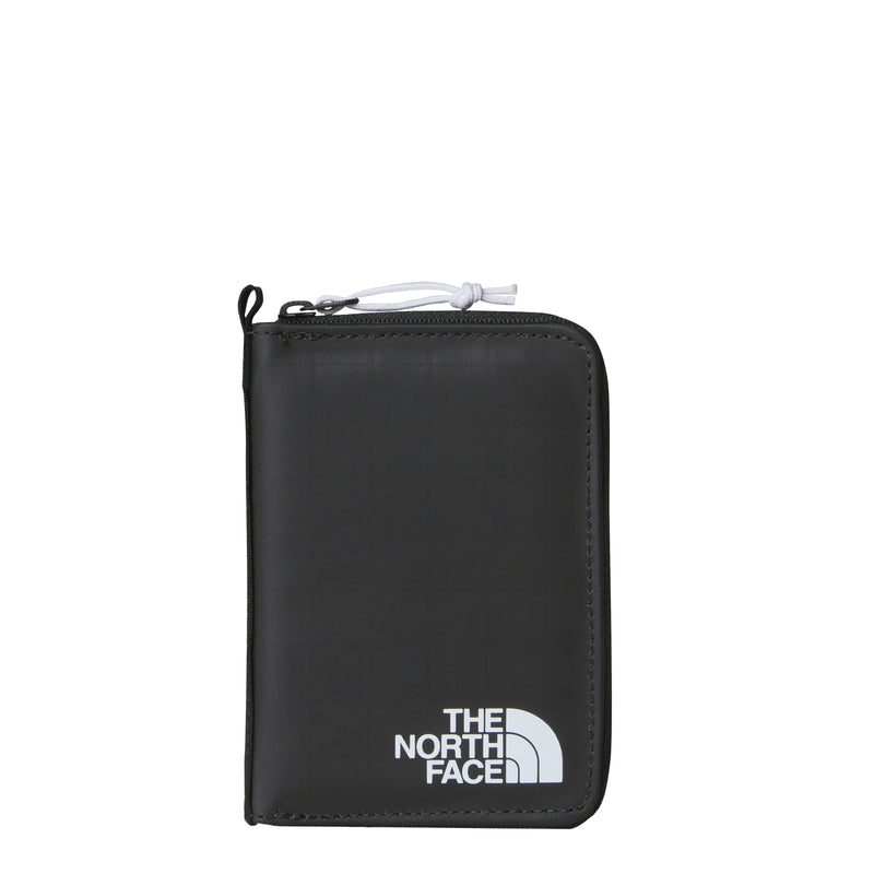 The North Face Base Camp Voyager Wallet is a sleek black zippered travel wallet made from recycled fabric, featuring the brands white logo at the bottom right corner and a convenient pocket for a tracking tag.