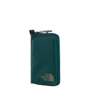 The North Face Base Camp Voyager Wallet in teal, crafted from recycled fabric, stands upright against a white background with a gray logo on the lower front corner. Designed as a practical travel wallet, it features a zip closure and an integrated tracking tag pocket for added security while on the go.