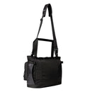 A black Base Camp Voyager Tote Bag by The North Face, crafted from recycled durable fabric for everyday use, is shown on a white background. This versatile messenger-style bag features an adjustable shoulder strap, side pocket, and flap closure, offering a spacious 25-litre capacity to keep all your essentials organized and secure.