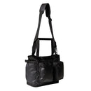 A black Base Camp Voyager Tote Bag from The North Face—featuring a wide adjustable strap, multiple compartments, and zippered front pockets, all crafted from recycled durable fabric—is displayed against a white background.