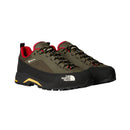 A pair of Men’s Verto GORE-TEX Alpine Shoes by The North Face, featuring an olive green and black exterior with a red interior, yellow accents, and rugged Vibram outsoles, are displayed side by side on a white background to highlight their durable, waterproof hiking footwear design.