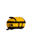Introducing the Base Camp Mini Duffel by The North Face—a compact yellow and black pouch with black trim, a zipper closure, and The North Face logo on the front. This small duffel makes an ideal keychain bag for carrying essentials on the go.