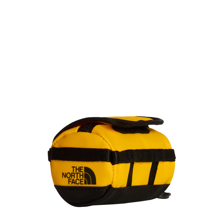 A compact, cylindrical yellow Base Camp Mini Duffel by The North Face, designed with black straps and trim and displaying the brand’s logo on the front. Durable construction makes it ideal for travel or outdoor adventures.