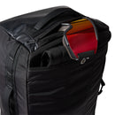 A black Great Outdoors Base Camp Boot Bag with a partially open top zipper reveals a colorful laptop or tablet and a rolled-up item inside, making it perfect as a versatile ski boot bag for your next adventure.