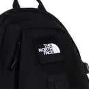 Close-up of a black The North Face Hot Shot Sling Bag featuring a stitched patch with The North Face logo in white on the upper front pocket, against a plain white background.