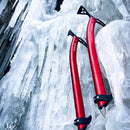 Two red ice axes with black handles against a frozen rock background